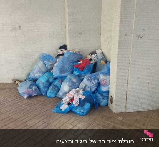 שקיות כחולות מלאות בבגדים מונחות על הרצפה